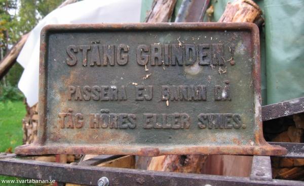Skylt »Stäng grinden. Passera ej banan då tåg höres eller synes.« den 3 oktober 2004. - klicka för att stänga rutan