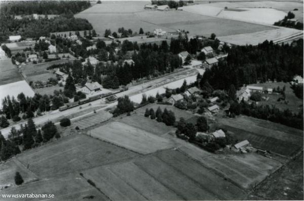 Flygfoto över Kvistbro med tåg vid stationshuset. - klicka för att stänga rutan