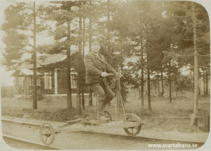 Banvakt Johan Erik Lindberg på cykeldressin med Kvistbro banvaktstuga i bakgrunden någon gång före 1930. - klicka för att stänga rutan