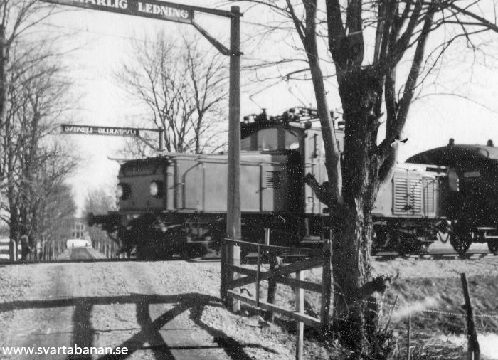 Ett elloksdraget tåg vid korsningen mellan Svartåbanan och Södra Holmstorp någon gång i mars 1956. - klicka för att stänga rutan